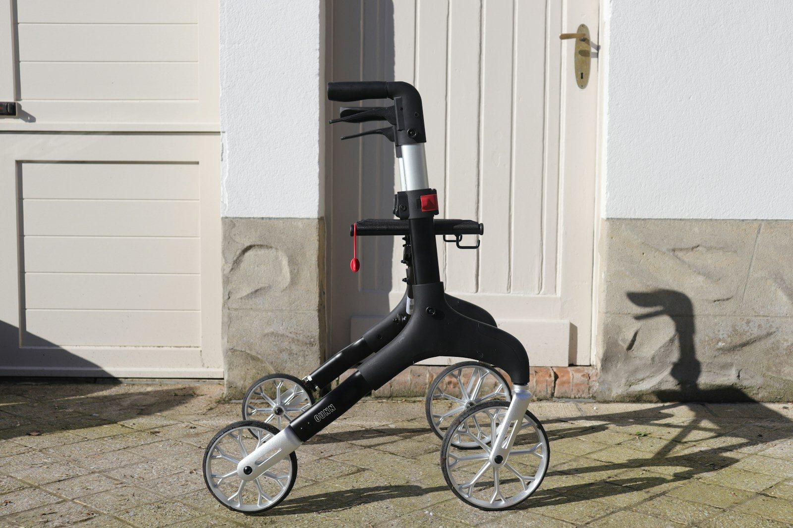 Upright Walkers vs. Standard Rollators: Which is Better for Your Posture? A modern black and silver walker with four wheels
